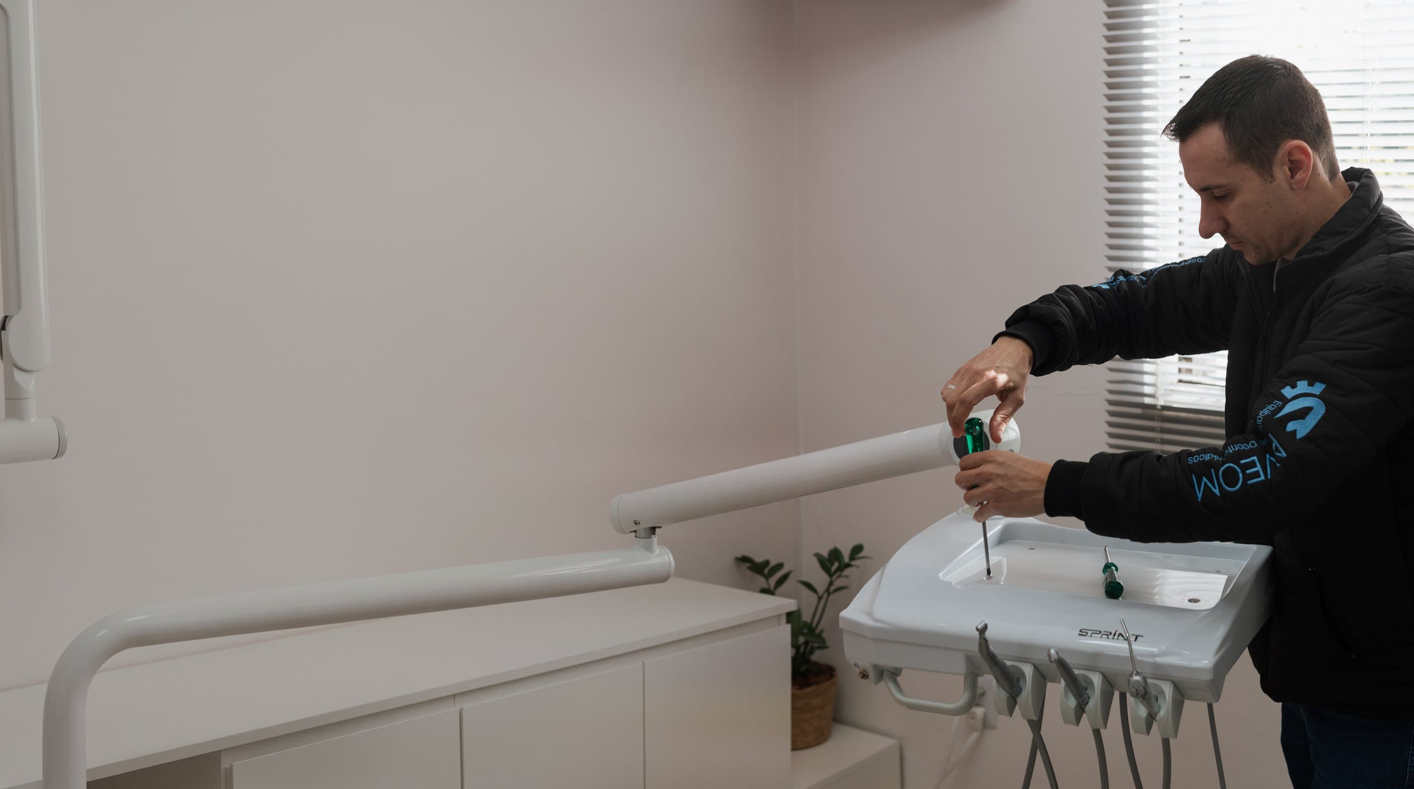 Técnico da Aveom fazendo a manutenção de um equipo odontológico