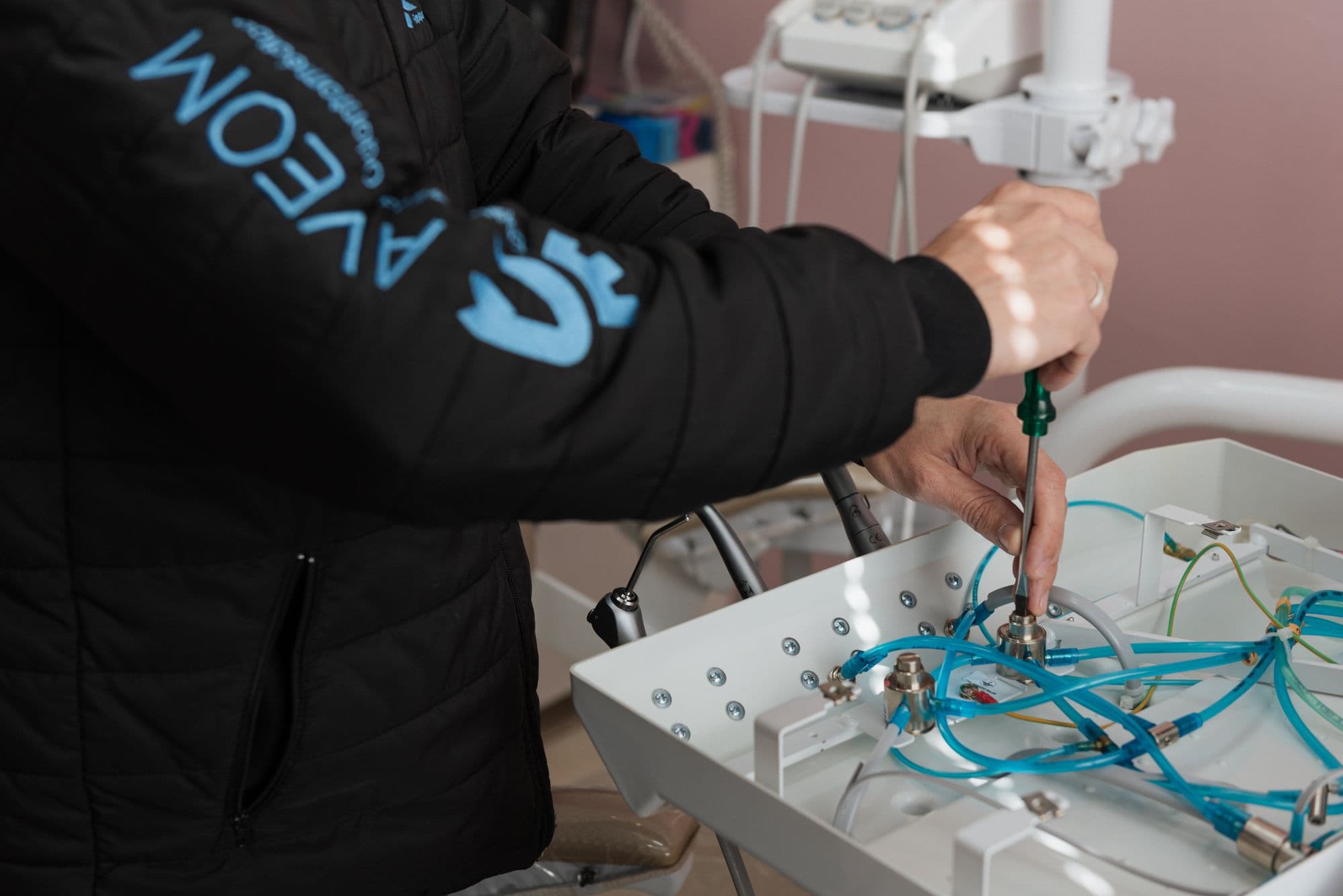 Técnico da Aveom ajustando as conexões de um equipo odontológico