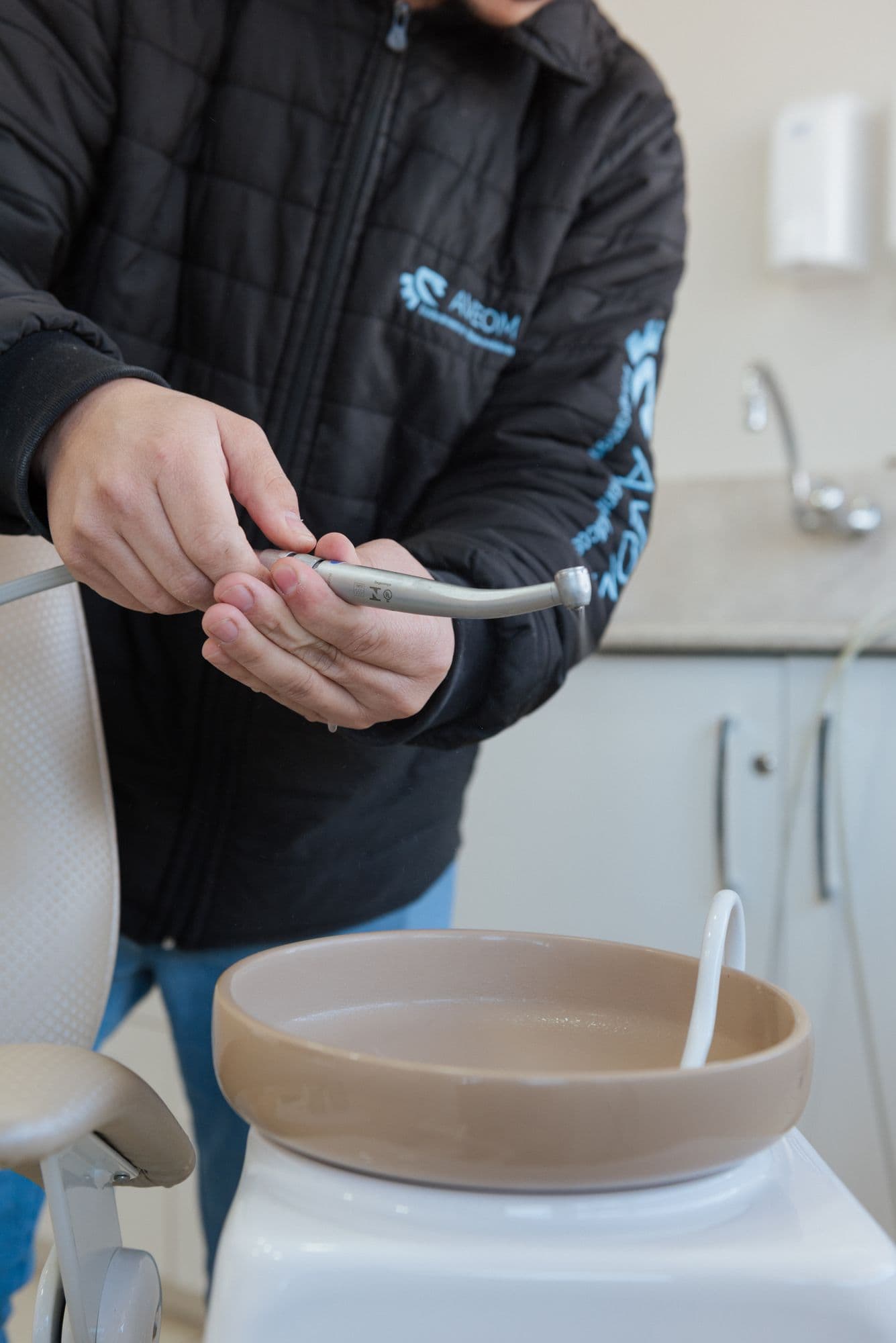 Técnico da Aveom inspecionando uma peça de mão odontológica